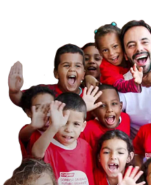 Un gruppo di bambini sorridenti che salutano, con indosso magliette rosse Colgate, insieme a un uomo sorridente in camicia bianca